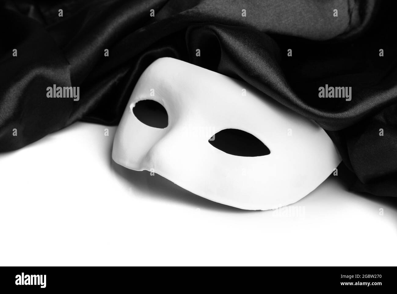 White mask and black silk fabric, isolated on white Stock Photo - Alamy