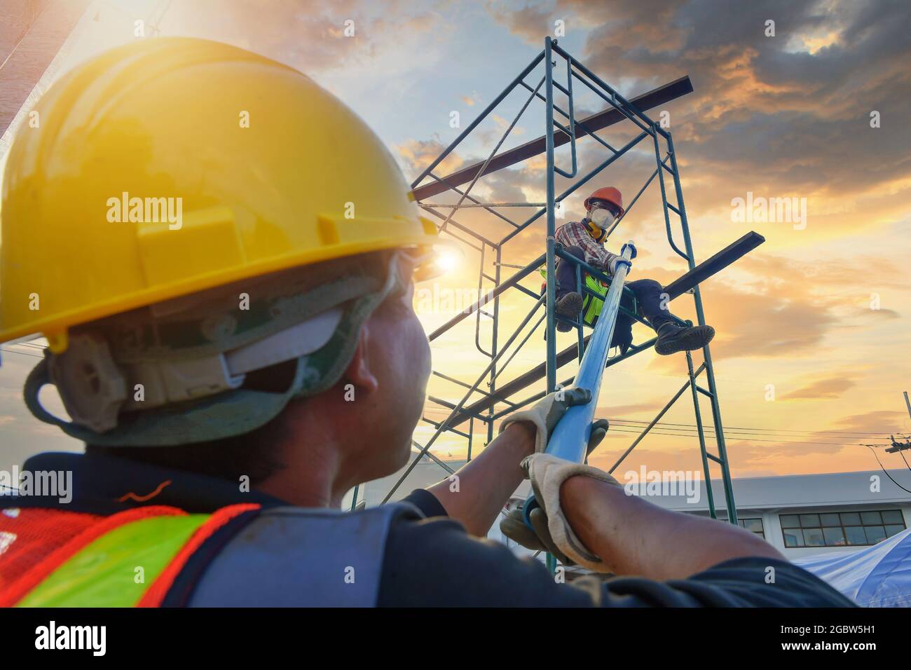 Construction worker wearing safety work at high uniform on scaffolding ...