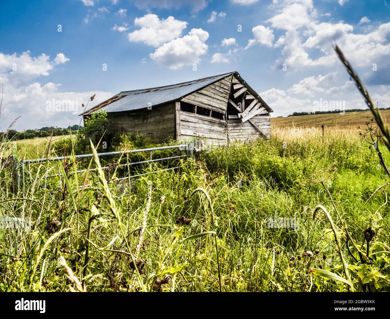 A dilapidated barn on the edge of a field. Stock Photo
