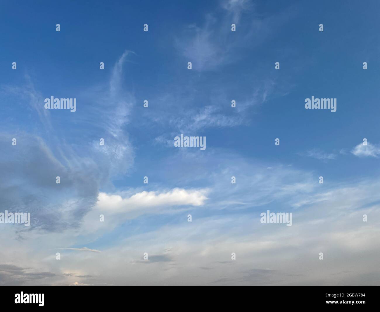 Pattern of clouds forming in blue sky creating an abstract background Stock Photo