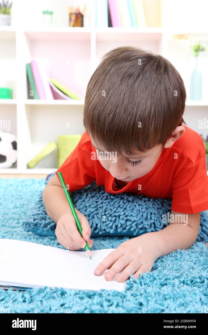 Cute little boy drawing in his album Stock Photo - Alamy