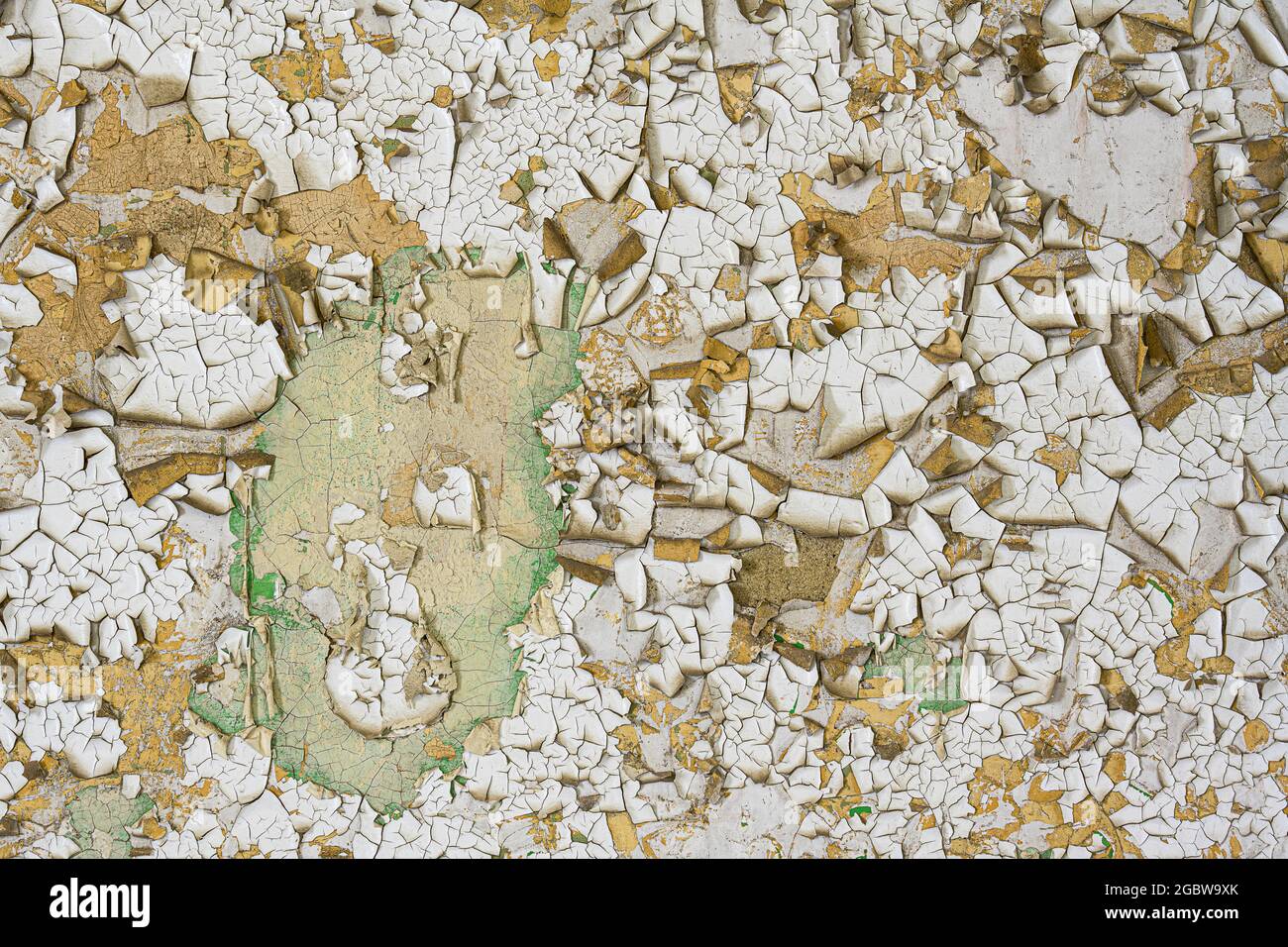 Cracked and peeling white and beige paint forms abstract background Stock Photo