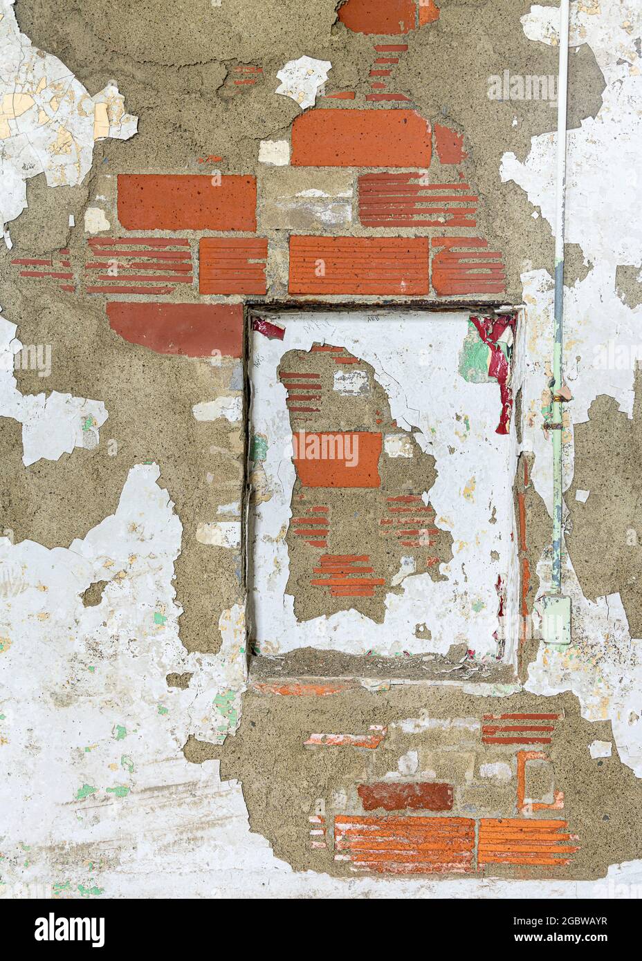 Decayed red brick wall with peeling paint forms abstract background Stock Photo