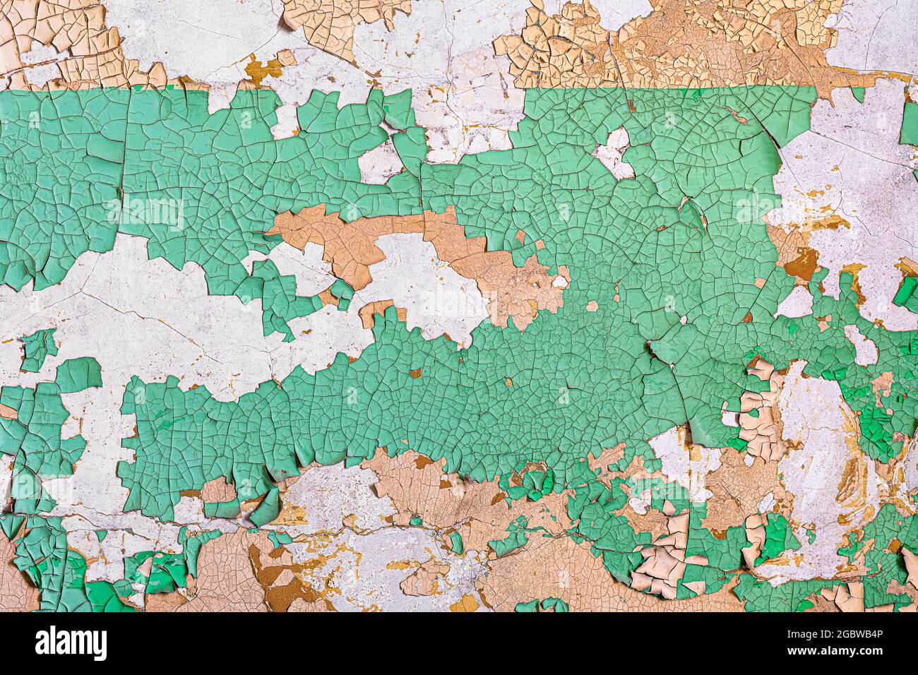 Decayed wall with peeling green paint forms abstract background Stock Photo