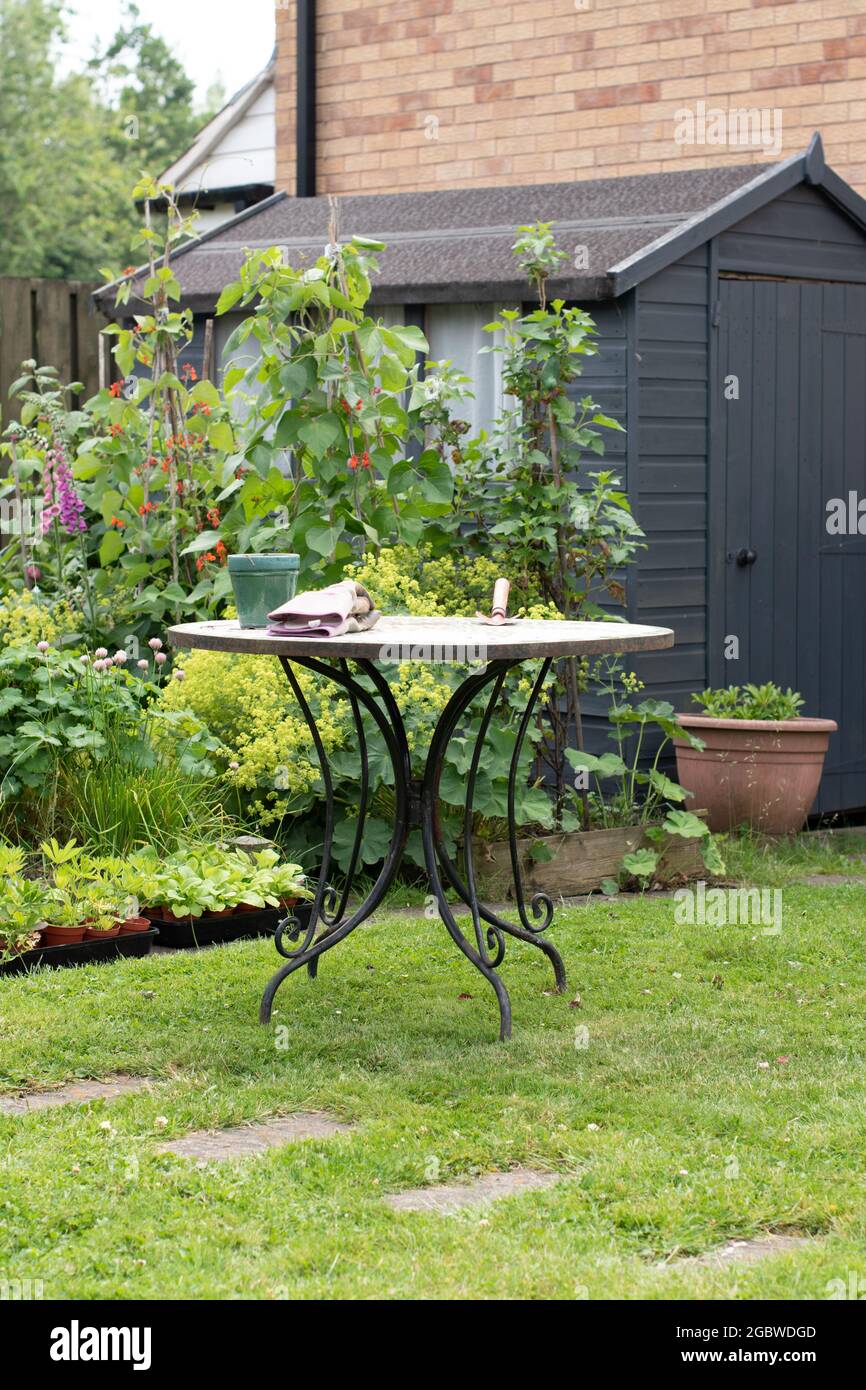 Authentic garden scene with garden table , wooden shed, lawn area Stock Photo