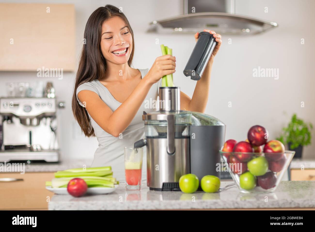 Green juice woman juicing celery and apple juice with juicer