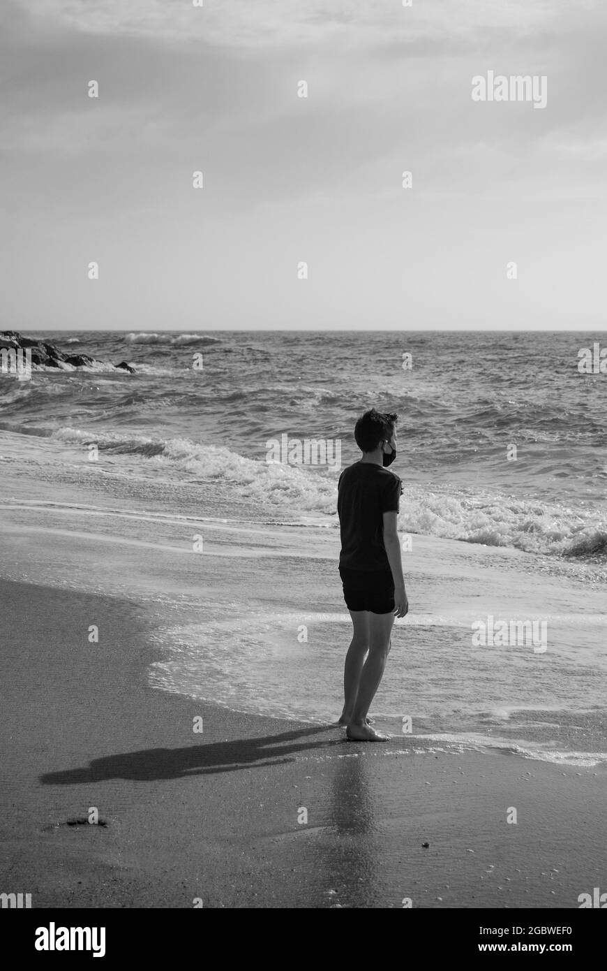 Silhouette boy standing at beach alone hi-res stock photography ...
