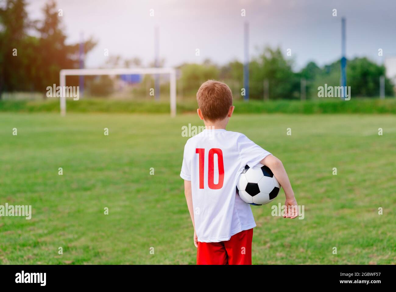 8 years old boy child holding football ball on playing field Stock Photo Alamy