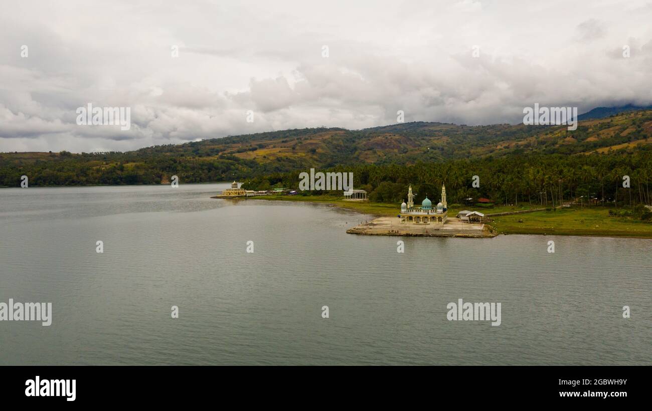 Aerial drone of Mosque and lake Lanao surrounded by mountains. Mindanao, Lanao del Sur, Philippines. Stock Photo