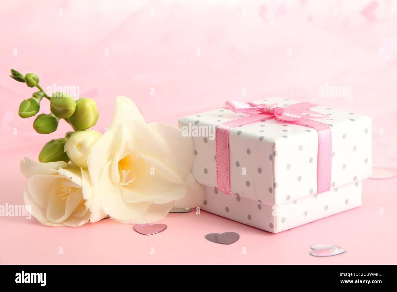 Beautiful romantic gift box and flower on pink background Stock Photo