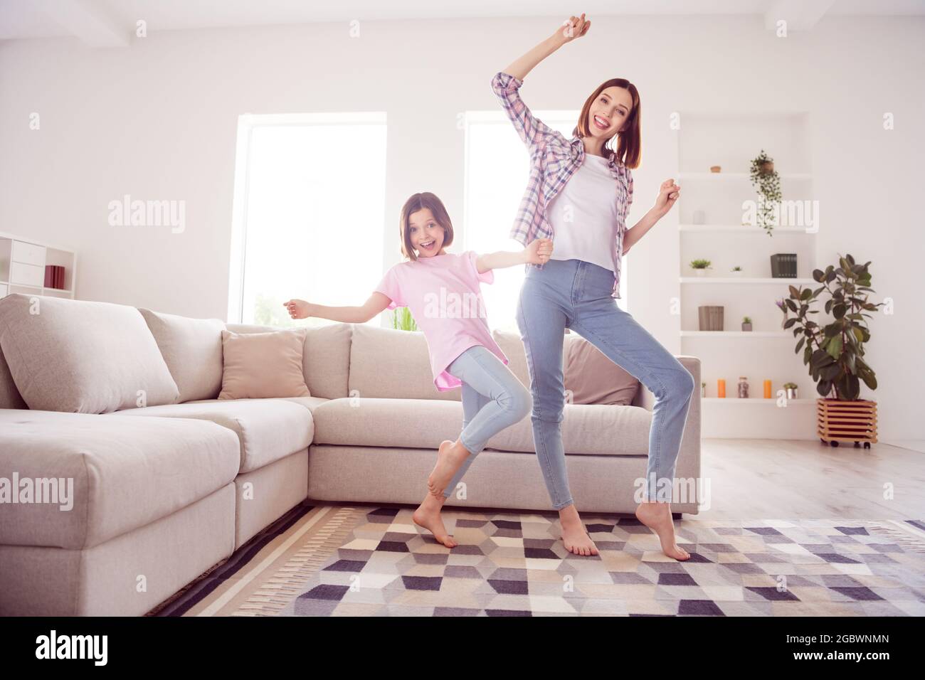 Full length photo of cheerful sisters siblings good mood winner raise ...