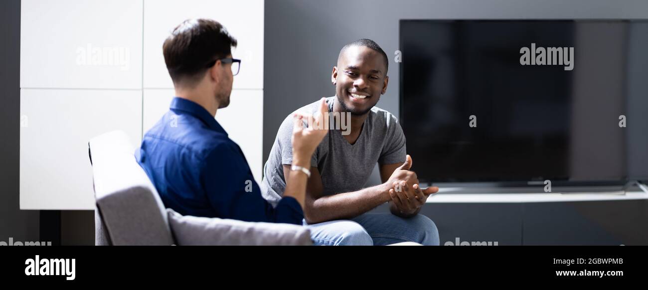 Couple Using Sign Language. Deaf African American On Sofa Stock Photo