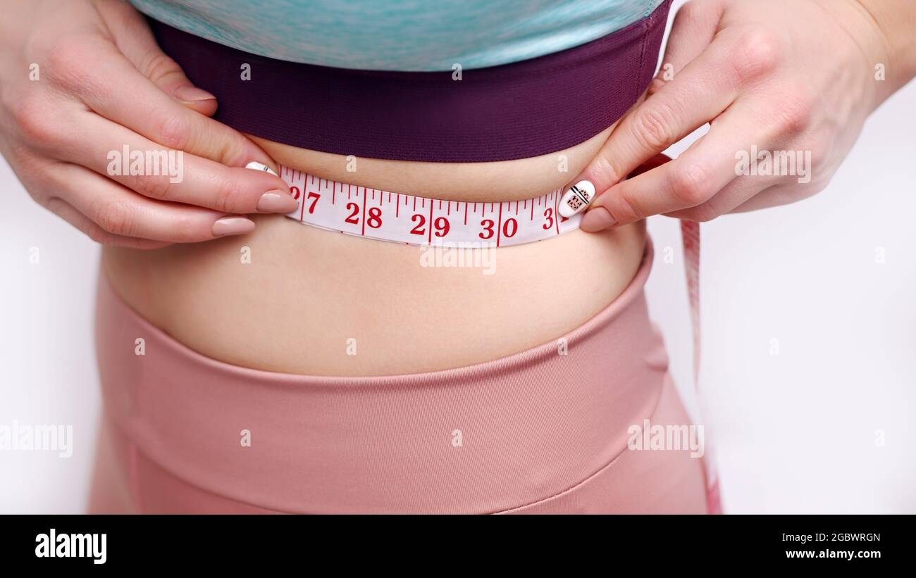 https://c8.alamy.com/comp/2GBWRGN/sporty-girl-holding-a-measuring-tape-measuring-her-waist-closeup-shot-isolated-over-white-background-studio-shot-concept-of-losing-weight-diet-and-healthy-lifestyle-2GBWRGN.jpg