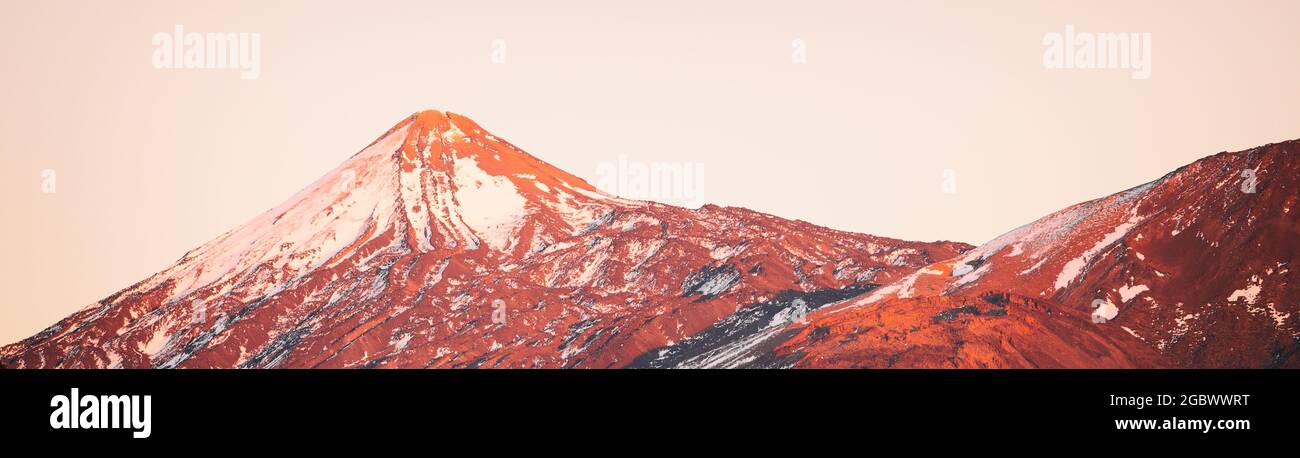 Volcano mountain peak landscape at sunset covered in snow winter background header. Panoramic of Teide Pico del Teide top, Tenerife, Canary Islands Stock Photo