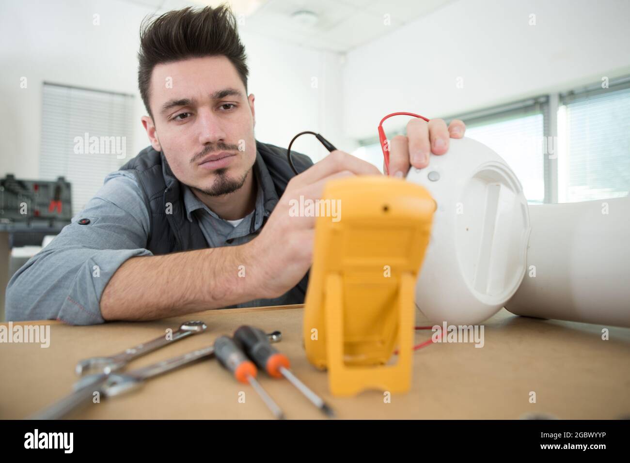 engineer testing appliance with a multimeter Stock Photo - Alamy
