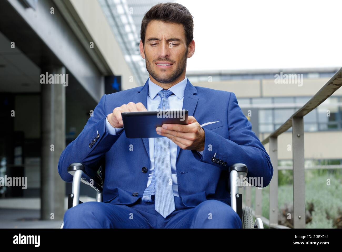 disabled businessman on wheelchair checking tablet Stock Photo