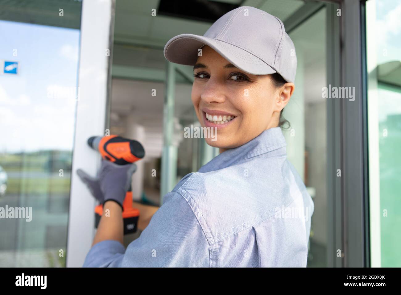 female builder using cordless electric screwdriver Stock Photo
