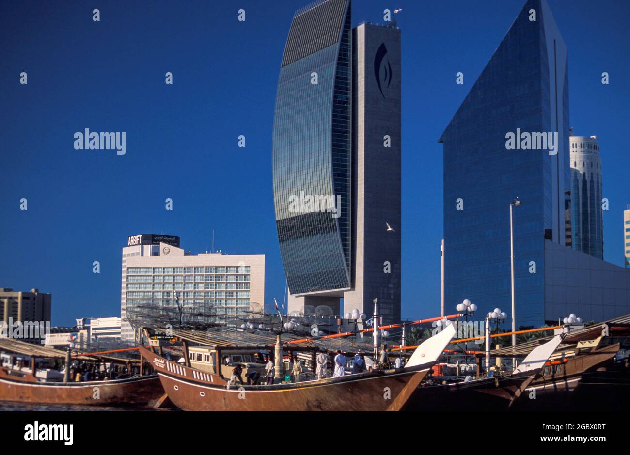 Cargo ships and Emirates NBD headquarters building in Deira, Abra boat ride across the Dubai Creek, Dubai, United Arab Emirates Stock Photo