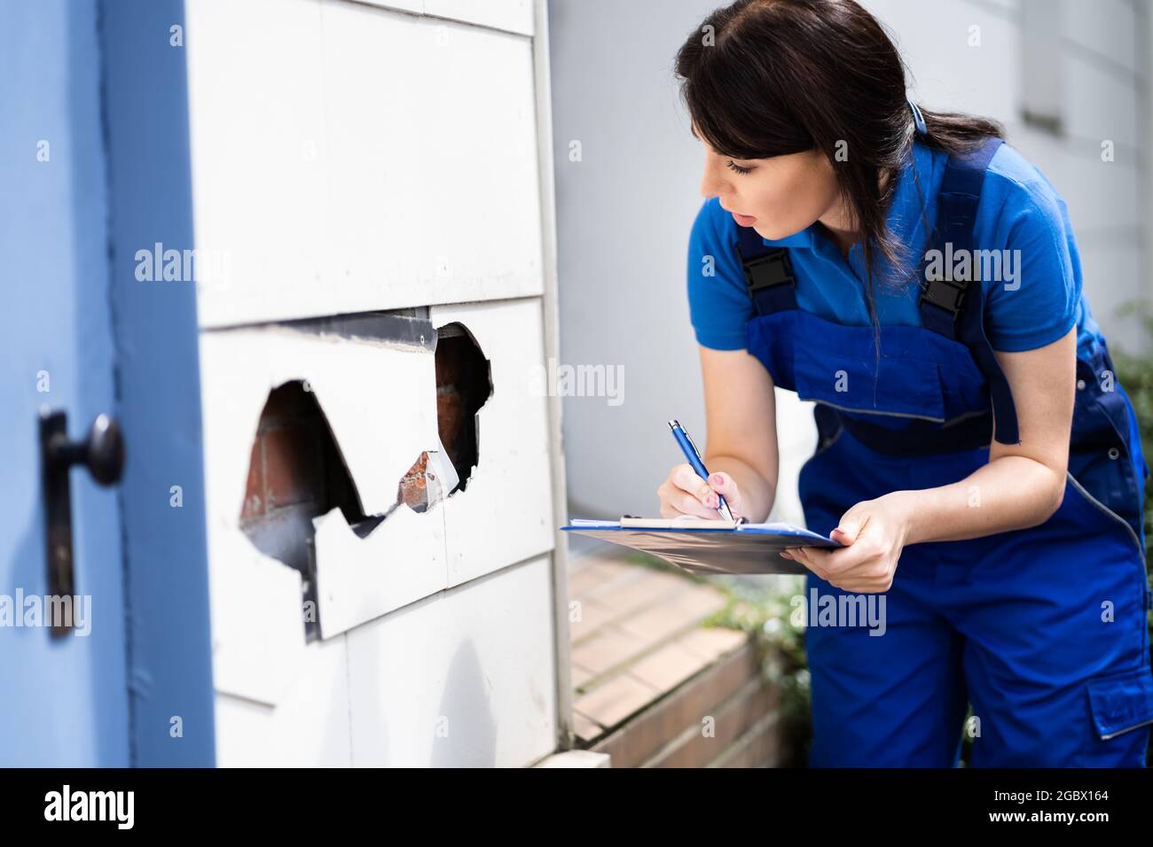 Real Estate Property Appraisal. Woman Inspecting House Stock Photo