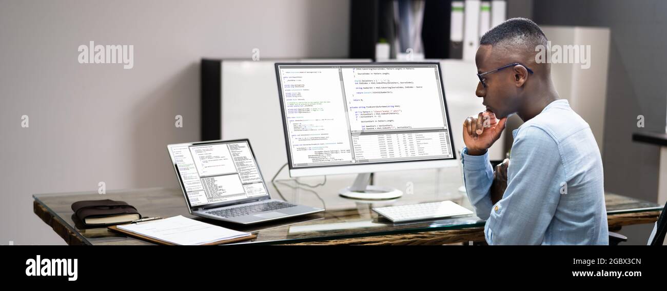 African American Coder Using Computer At Desk. Web Developer Stock Photo