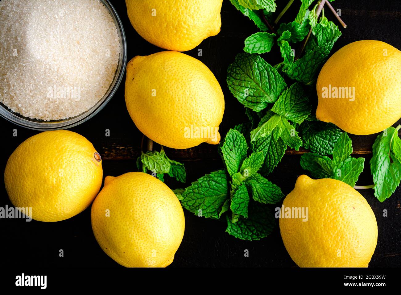 Limonata Turkish Lemonade Ingredients on a Wood Background: Lemons, sugar, and mint leaves on a wooden table Stock Photo