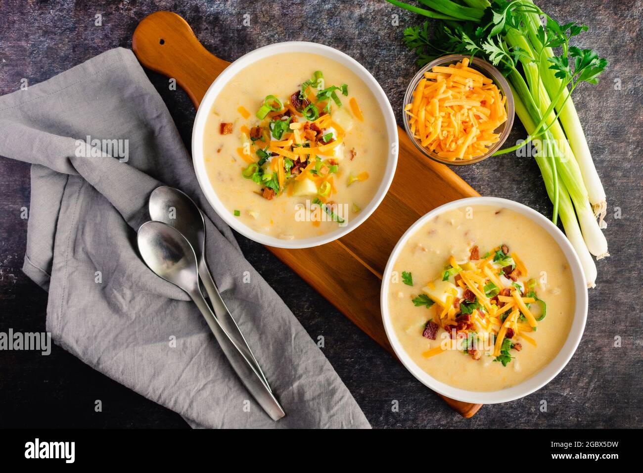 Bowls of Loaded Baked Potato Soup Topped with Sour Cream, Cheddar Cheese, Bacon, and Chives: Creamy potato soup garnished with sour cream, shredded ch Stock Photo