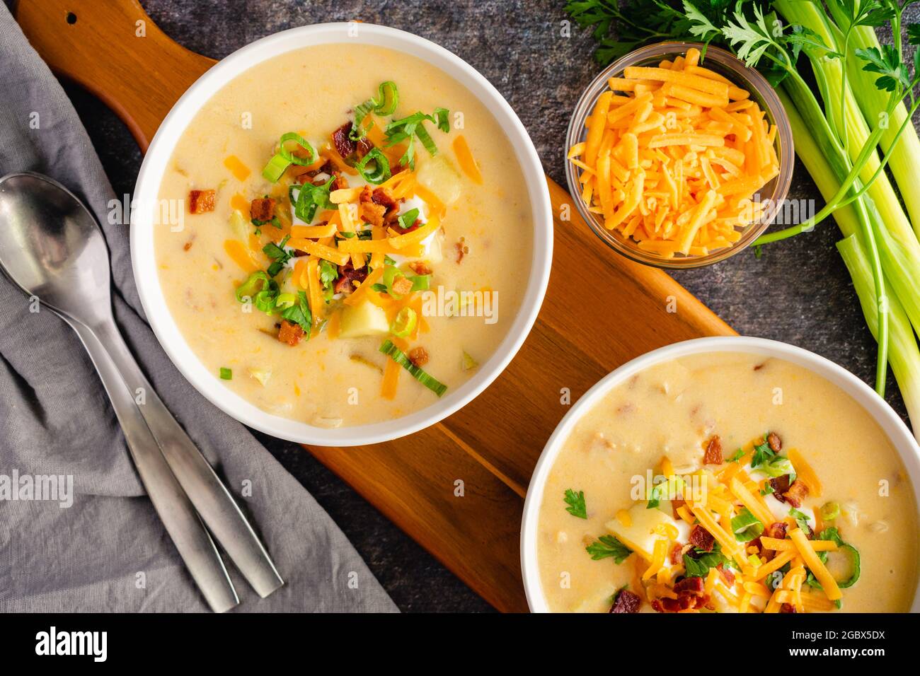 Bowls of Loaded Baked Potato Soup Topped with Sour Cream, Cheddar Cheese, Bacon, and Chives: Creamy potato soup garnished with sour cream, shredded ch Stock Photo