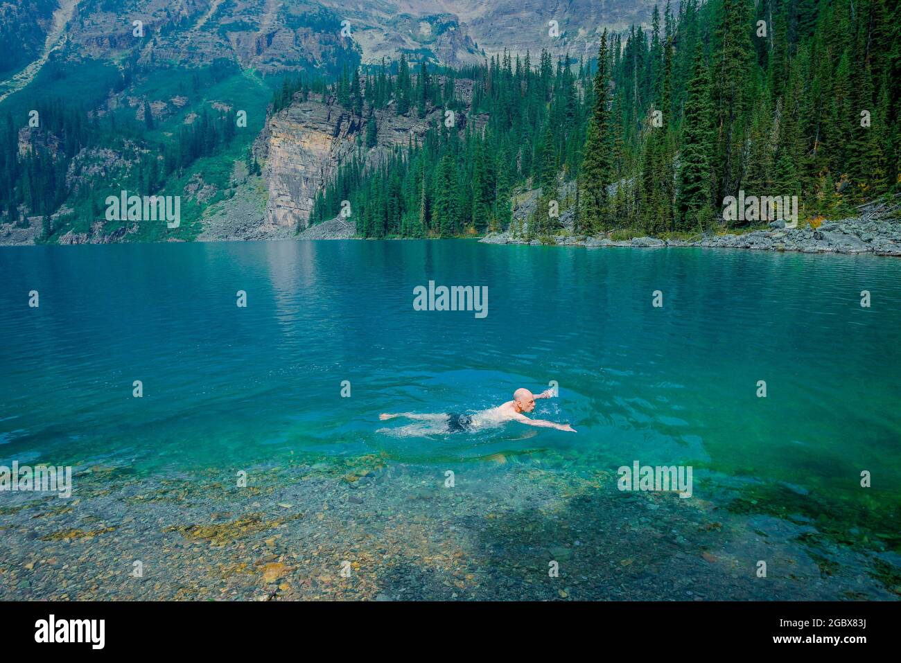 Man swimming, Lake O'Hara, Yoho National Park, British Columbia, Canada Stock Photo