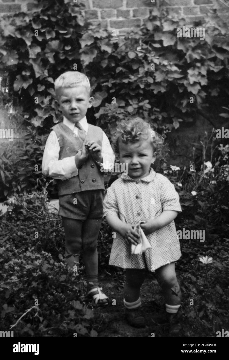 Two siblings in backyard garden. Archival photo circa 1969. Bulgaria, Balkans, Eastern Europe Stock Photo