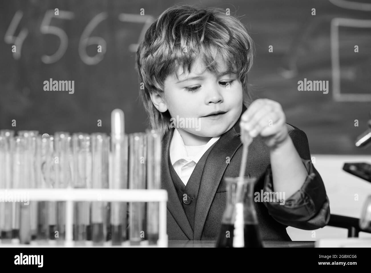school kid scientist studying science. science experiments with microscope in lab. Little boy is