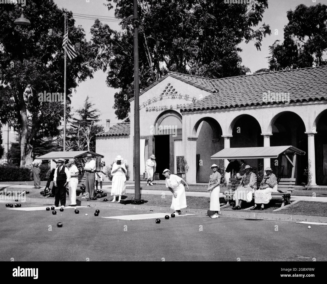 1930s GROUP OF ELEGANTLY SPORTS DRESSED MEN AND WOMEN PARTICIPATING IN AND ENJOYING BOWLS OR LAWN BOWLS AT COUNTRY CLUB - asp ap10 801 ASP001 HARS JOY LIFESTYLE ELDER FEMALES HEALTHINESS COPY SPACE FRIENDSHIP FULL-LENGTH LADIES PHYSICAL FITNESS PERSONS BOWLS MALES ATHLETIC SENIOR MAN SENIOR ADULT B&W SENIOR WOMAN OLD AGE OLDSTERS OLDSTER LEISURE STRATEGY AND ENJOYING EXTERIOR RECREATION COUNTRY CLUB AT IN OF ON UPSCALE ELDERS AFFLUENT ELEGANTLY STARS AND STRIPES STYLISH UNUSUAL OLD GLORY OR BOWLING GREEN KITTY PLAYED RED WHITE AND BLUE RELAXATION TOGETHERNESS WELL-TO-DO BLACK AND WHITE Stock Photo