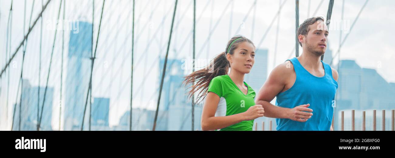 Athletes runners running on New York city Brooklyn Bridge for Marathon training, fitness workout of Asian woman and Caucasian man, interracial couple Stock Photo