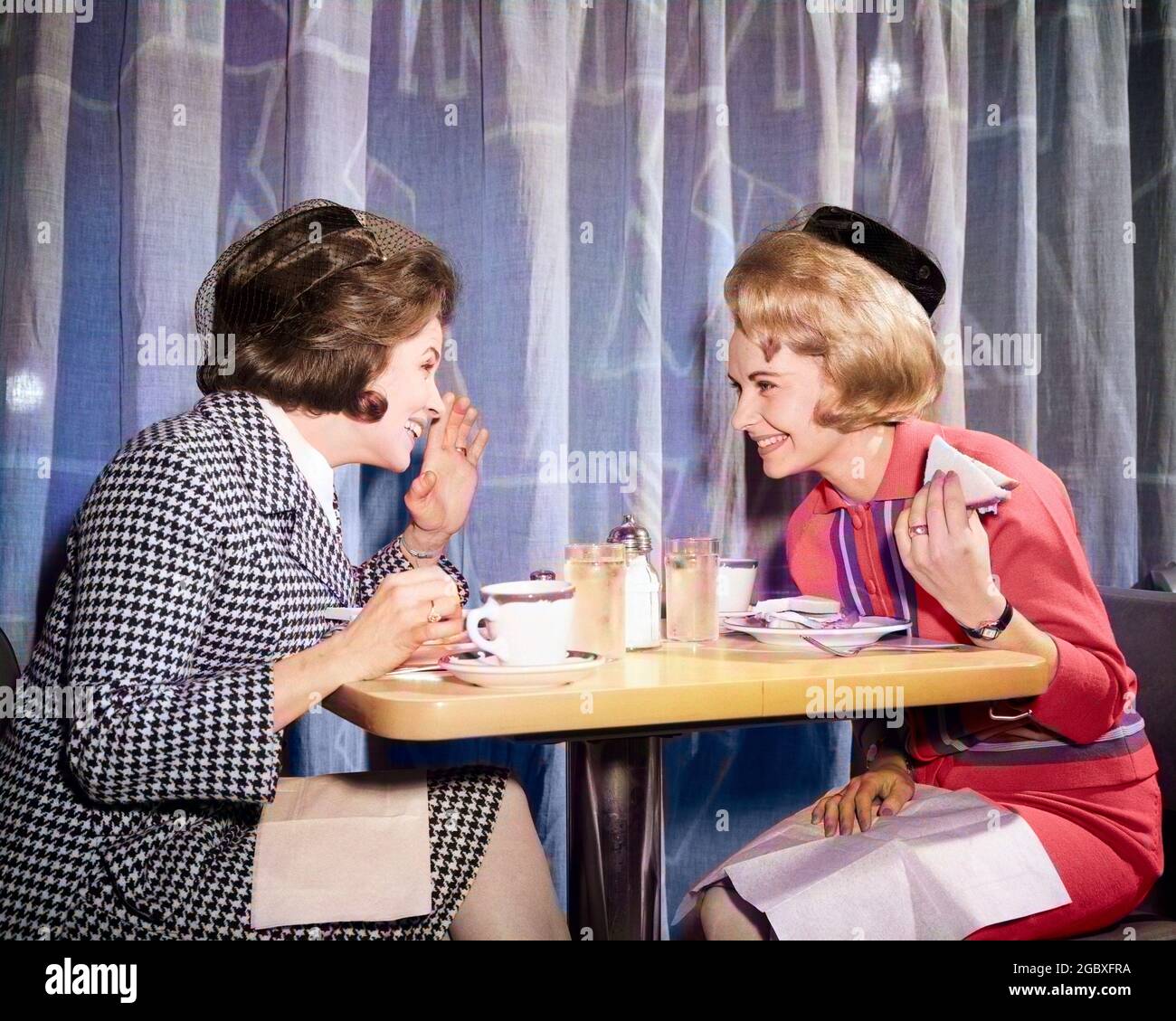1960s TWO WOMEN GOSSIPING AT LUNCH IN RESTAURANT - d5256c HAR001 HARS COLOR SHARING CURTAIN RELATIONSHIP OLD TIME ARCHIVE NOSTALGIA LEANING OLD FASHION CONVERSATION STYLE COMMUNICATION FRIEND BEST INFORMATION SNACK LIFESTYLE LISTEN GOSSIP RELATION SEATED FRIENDSHIP HALF-LENGTH SIT SPEAK SUGAR VEIL AMERICANA SHARE GOSSIPING FOODS SNACK FOODS KNIT GIRLFRIEND PRIVATE SNACKS ARCHIVAL SNACK FOOD EXCITEMENT KNOWLEDGE PILLBOX TELLING DRAPERY CANDID FEMININE HOUNDS TOOTH LUNCHEON NEIGHBOR RUMOR STYLISH BEST FRIEND CONFIDANT HOUNDS-TOOTH LUNCHEONETTE MID-ADULT MID-ADULT WOMAN TOGETHERNESS Stock Photo
