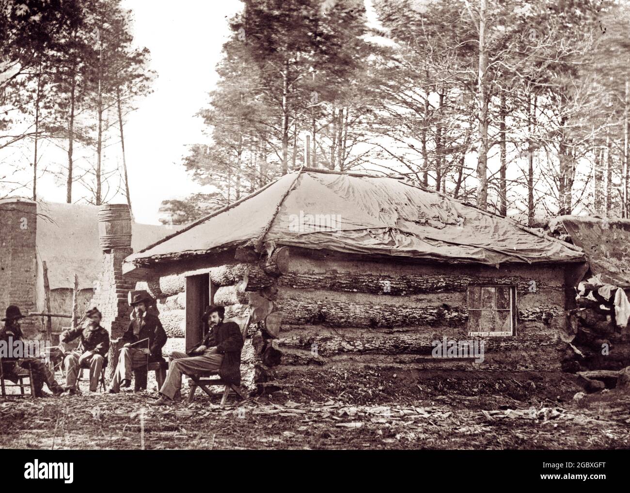 1800s 1860s OFFICERS LOG HUT WITH CANVAS ROOF AT UNION CAMP AMERICAN CIVIL WAR  - h8911 SPL001 HARS EXTERIOR HUT UNIFORMS REAL ESTATE CONNECTION STRUCTURES 1860s EDIFICE OFFICERS COOPERATION TOGETHERNESS AMERICAN CIVIL WAR BATTLES BLACK AND WHITE CIVIL WAR CONFLICTS OLD FASHIONED Stock Photo