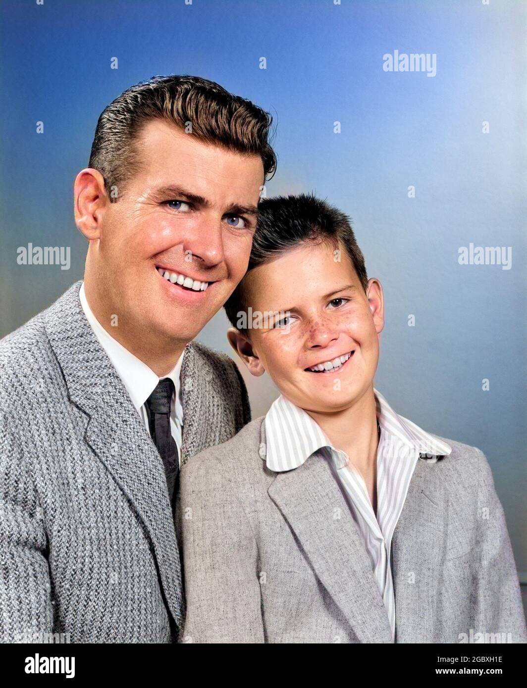 1950s STUDIO PORTRAIT SMILING MAN FATHER AND BOY SON SITTING TOGETHER LOOKING AT CAMERA - j6780c HAR001 HARS JOY STUDIO SHOT GROWNUP PEOPLE CHILDREN HALF-LENGTH PERSONS GROWN-UP CARING MALES EXPRESSIONS FATHERS EYE CONTACT FATHERHOOD SUIT AND TIE CHEERFUL AND DADS SMILES SPORTS JACKET JOYFUL PERSONAL ATTACHMENT SPORTS JACKETS AFFECTION EMOTION JUVENILES MID-ADULT MID-ADULT MAN PARENTHOOD YOUNGSTER CAUCASIAN ETHNICITY HAR001 OLD FASHIONED Stock Photo