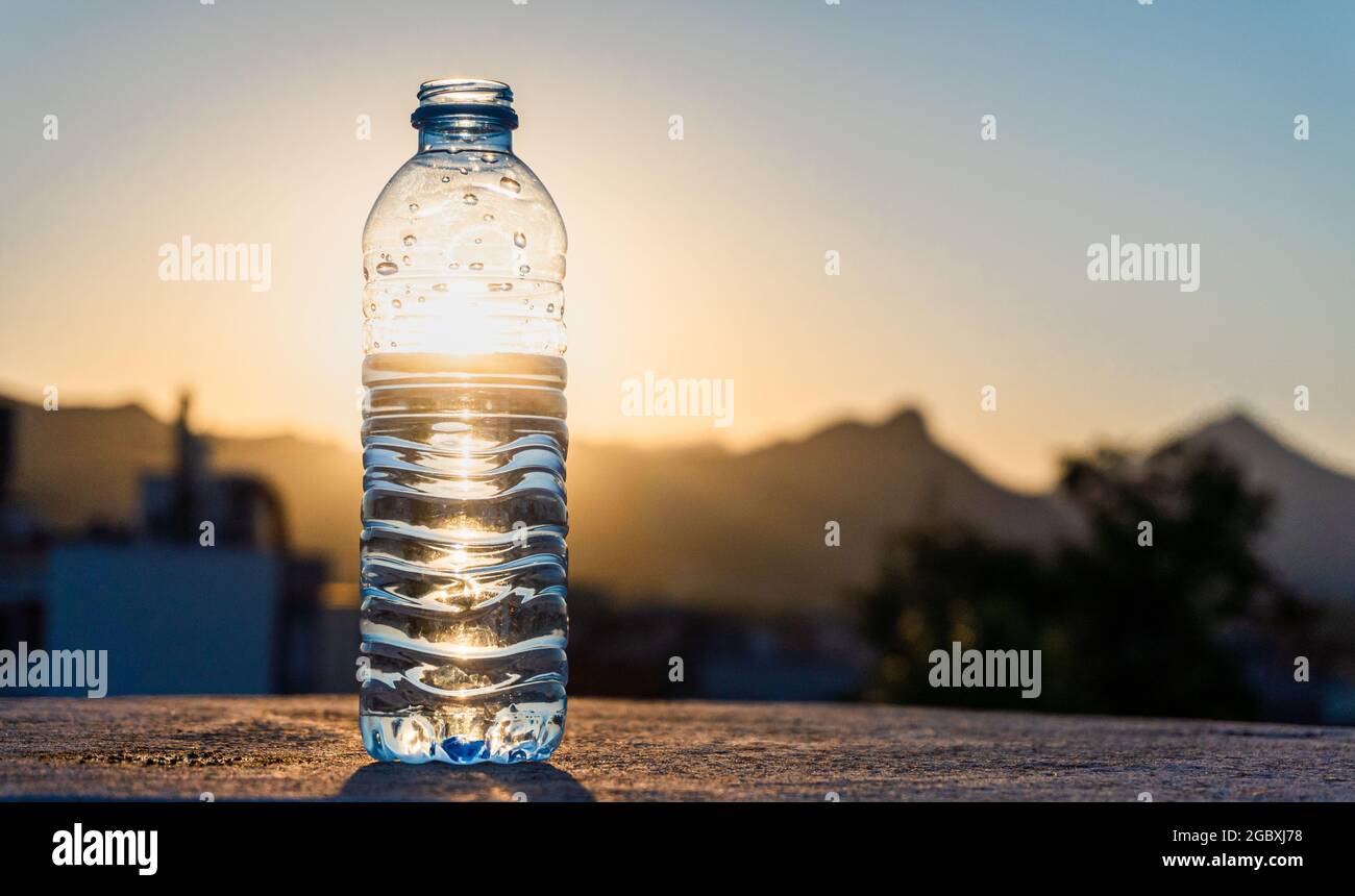 https://c8.alamy.com/comp/2GBXJ78/shallow-focus-of-a-plastic-water-bottle-standing-with-shiny-sunlight-with-blurred-park-in-background-2GBXJ78.jpg