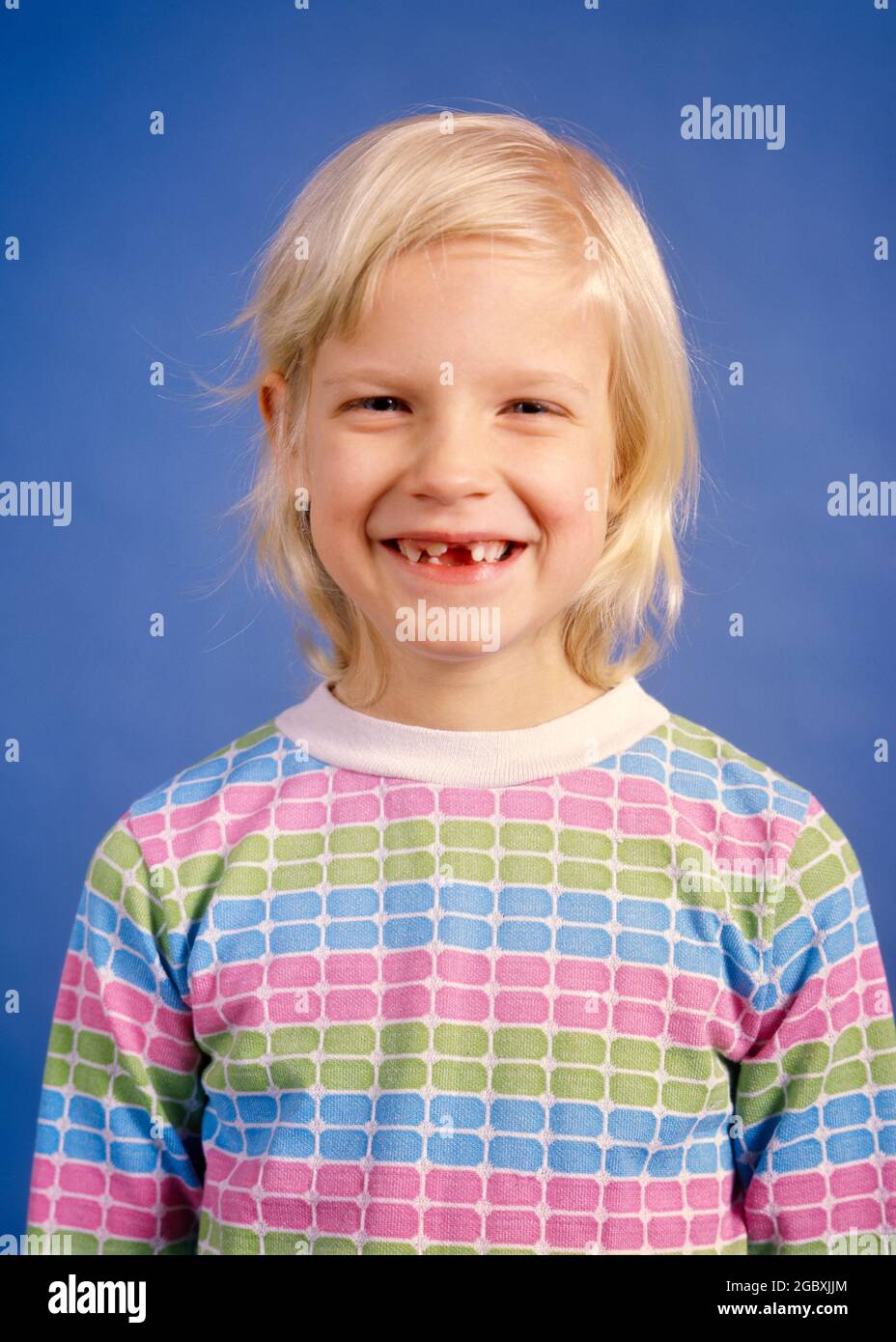 1970s SMILING BLOND GIRL MISSING HER FRONT TEETH LOOKING AT CAMERA WEARING PASTEL STRIPED SHIRT - kj8228 HAR001 HARS STUDIO SHOT HEALTHINESS HOME LIFE COPY SPACE HALF-LENGTH MISSING CONFIDENCE EYE CONTACT HUMOROUS HAPPINESS CHEERFUL DISCOVERY SMILES JOYFUL PLEASANT AGREEABLE CHARMING GROWTH JUVENILES LOVABLE PASTEL PLEASING ADORABLE APPEALING CAUCASIAN ETHNICITY HAR001 OLD FASHIONED Stock Photo