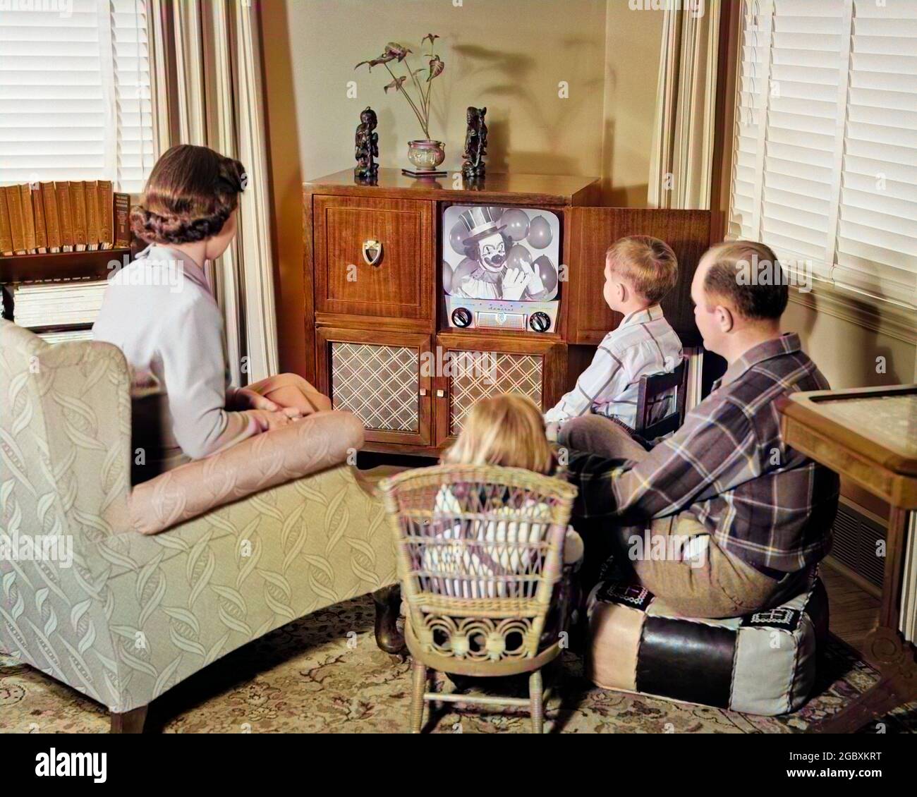 1950s BACK VIEW OF FAMILY OF 4 GATHERED AROUND TV SET WATCHING CLOWN WITH BALLOONS - r10116c HAR001 HARS CLOWN 4 COLOR RELATIONSHIP MOTHERS OLD TIME NOSTALGIA BROTHER MEDIA OLD FASHION SISTER APPLIANCE ELECTRICAL JUVENILE COMMUNICATION INFORMATION SONS FAMILIES PARENTING FEMALES MARRIED BROTHERS RELATION SPOUSE HUSBANDS GROWNUP HOME LIFE COMMUNICATING COPY SPACE HALF-LENGTH LADIES DAUGHTERS MAKEUP PERSONS CHARACTER MALES PRODUCT ENTERTAINMENT SIBLINGS SISTERS FATHERS MASS MEDIA PARTNER PATERNAL TELEVISIONS FATHERHOOD MATERNAL MAKE-UP BROADCASTING LEISURE OBSERVER LIVING ROOM AND DADS MAKE UP Stock Photo