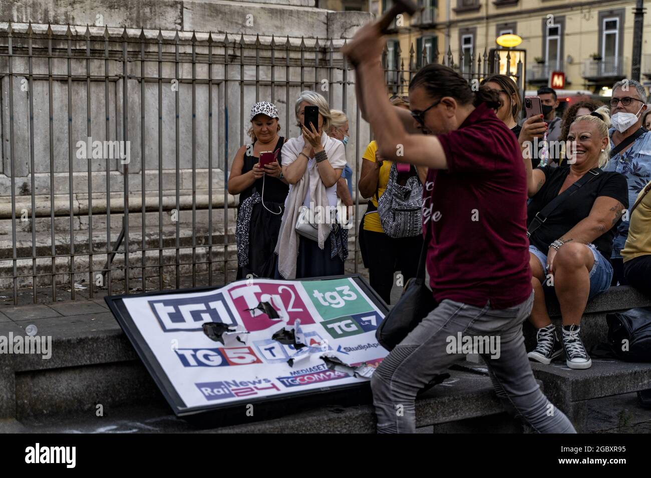 NAPLES, Italy. 05th Aug, 2021. In the absence of the march, the demonstrators 'No Green Pass' hammered a fake television, destroying it, in protest against the whole press, according to them subservient to the strong powers. "The state has allocated millions of euros to spread false news to the newspapers" is the accusation made by one of the organizers of the protest. Credit: Alessandro Barone/ Medialys Images/Alamy Live News Stock Photo