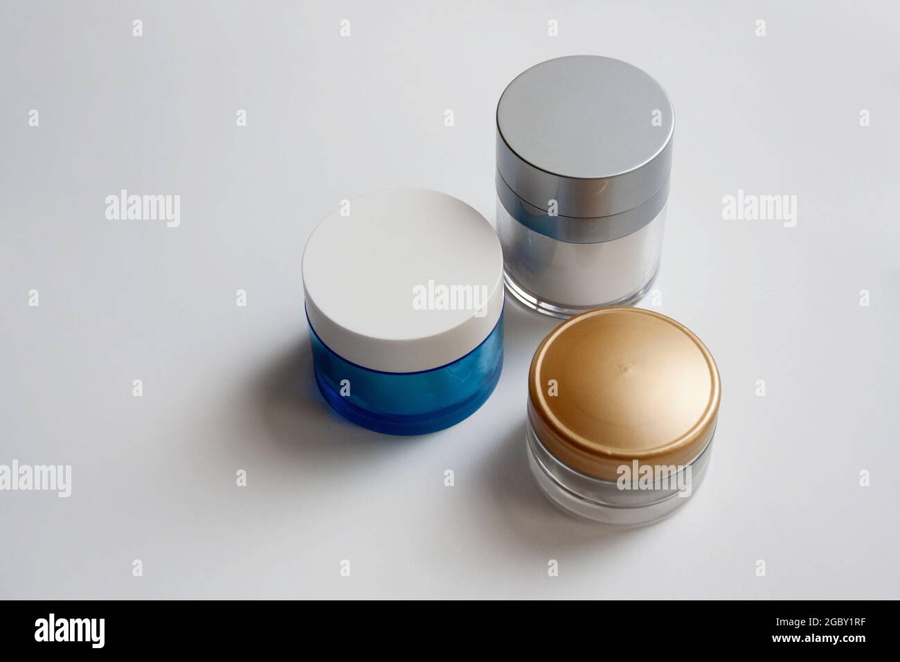 Three glass face cream jars isolated on white background Stock Photo