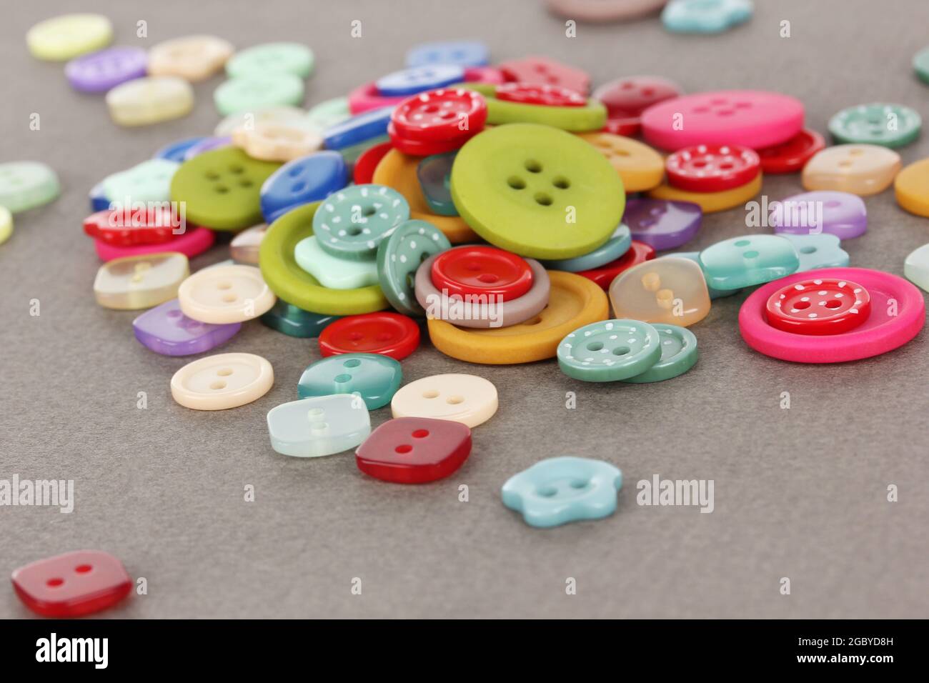 Buttons of different shapes, sizes and colors close-up on gray ...