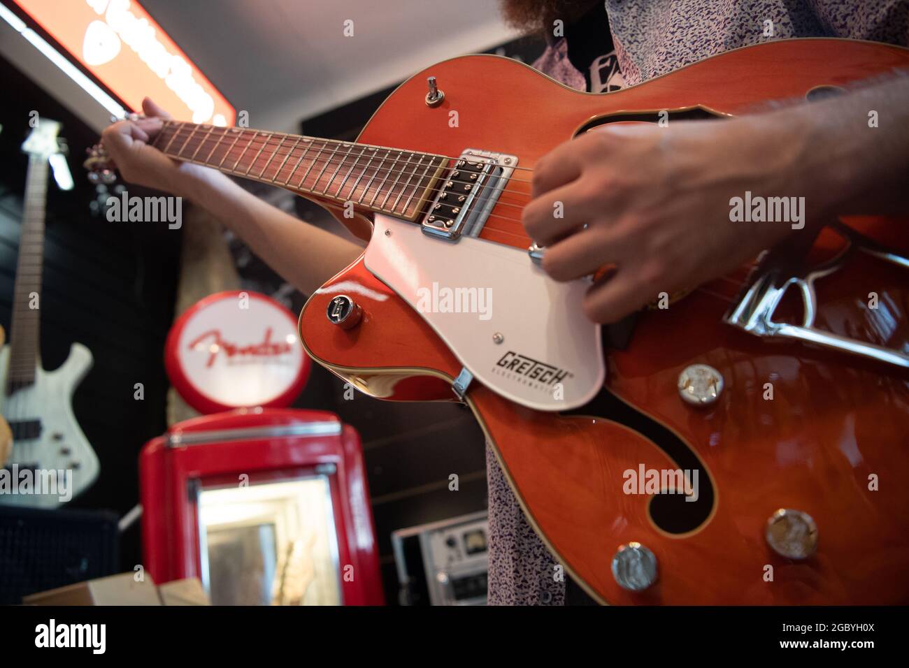 Berlin, Germany. 05th Aug, 2021. A man plays a left-handed guitar in a guitar  shop. Credit: Paul Zinken/dpa/Alamy Live News Stock Photo - Alamy