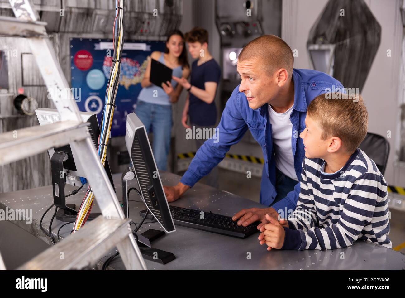 Portrait of a father and son in front of a computer in the quest room ...