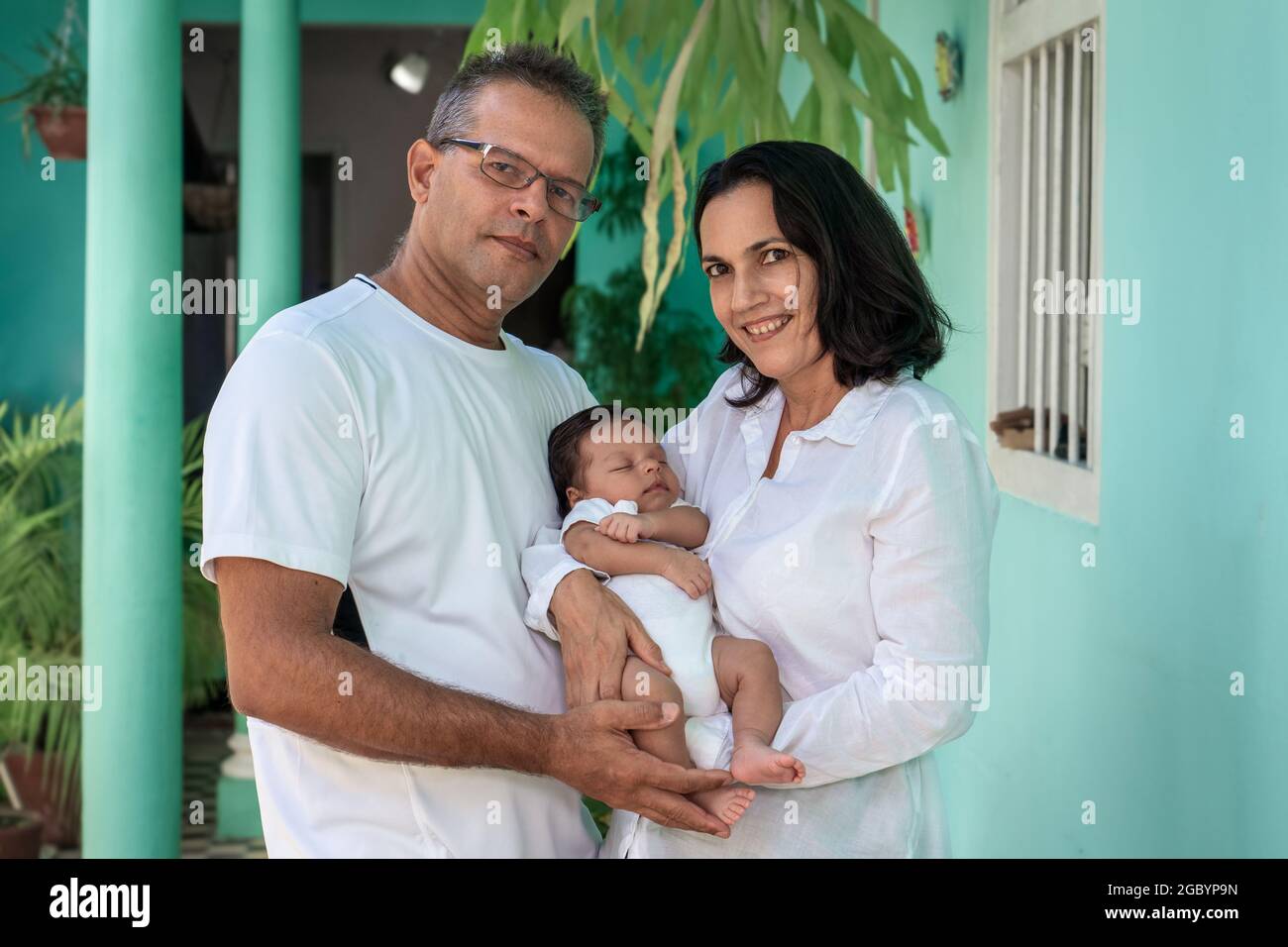 Photo of a baby in the arms of a woman and a man Stock Photo