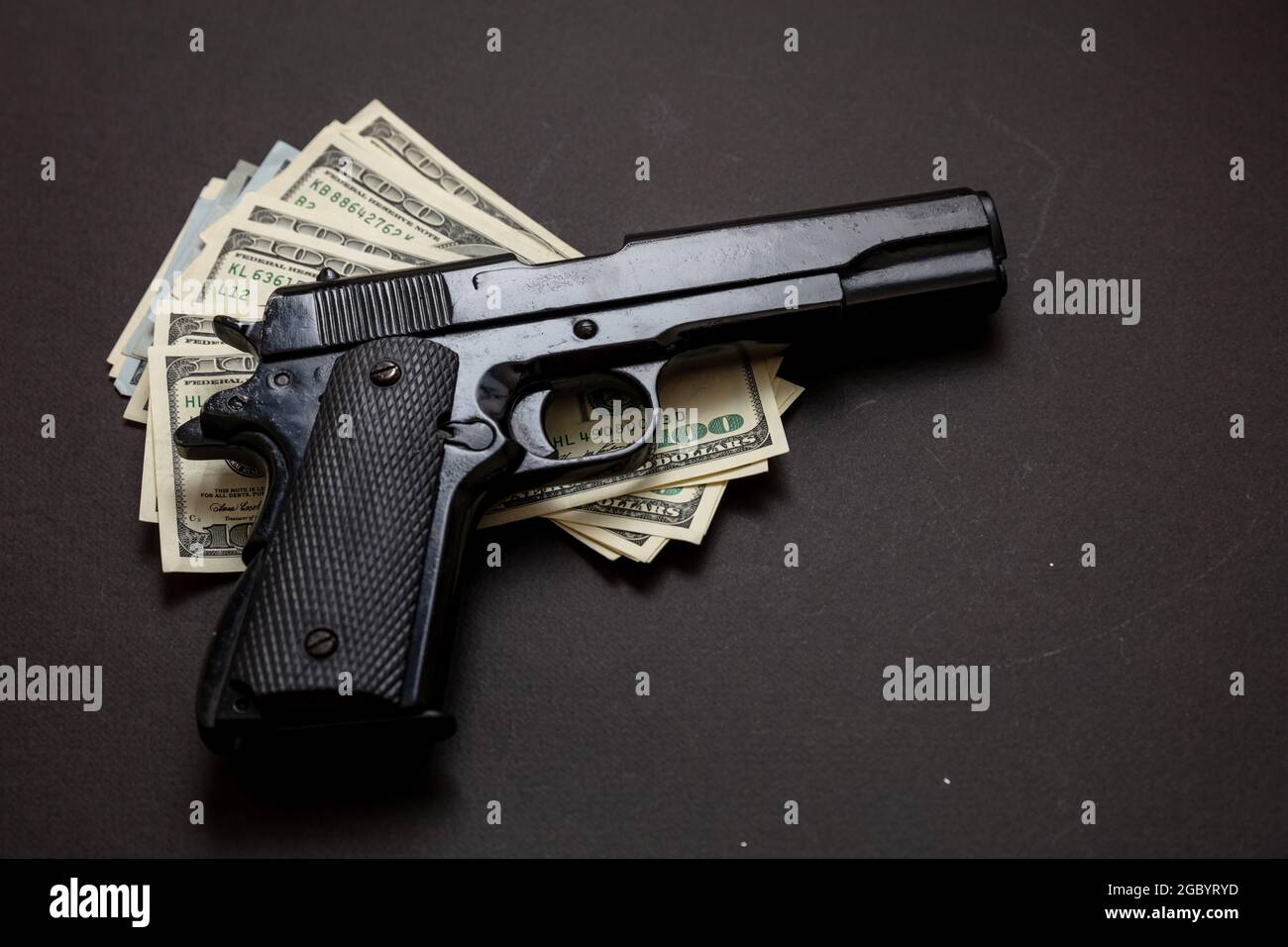 Criminal money, mafia and corruption concept, Crime concept, pistol handgun 9 mm and American dollar banknotes on black background. Stock Photo