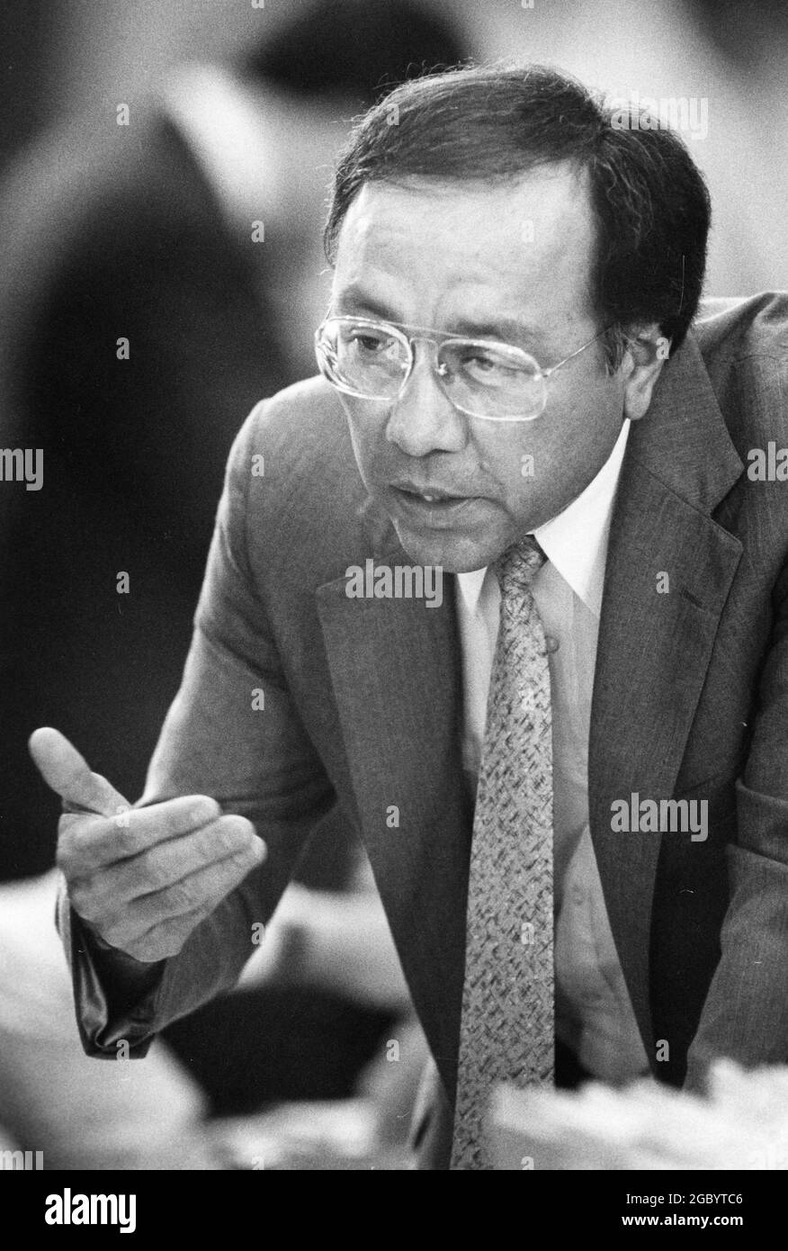 Austin Texas USA, 1989: State Rep. Juan 'Chuy' Hinojosa a Demorcrat from McAllen, speaks to a colleague on the floor of the Texas House of Representatives during the legislative session. ©Bob Daemmrich Stock Photo