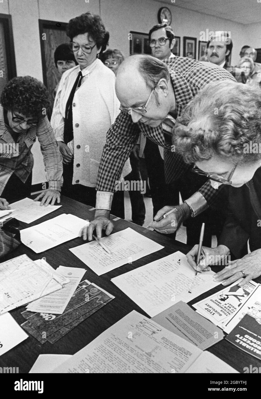 Austin, Texas USA, circa 1994: Neighborhood residents signing petitions about development as they arrive at public meeting to discuss contentious building proposal. ©Bob Daemmrich Stock Photo