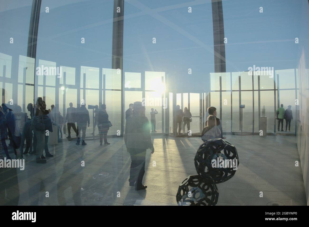 Menschen stehen im Gegenlicht der Sonne in einer Aussichtskuppel - People stand in the backlight of the sun in a viewing dome Stock Photo