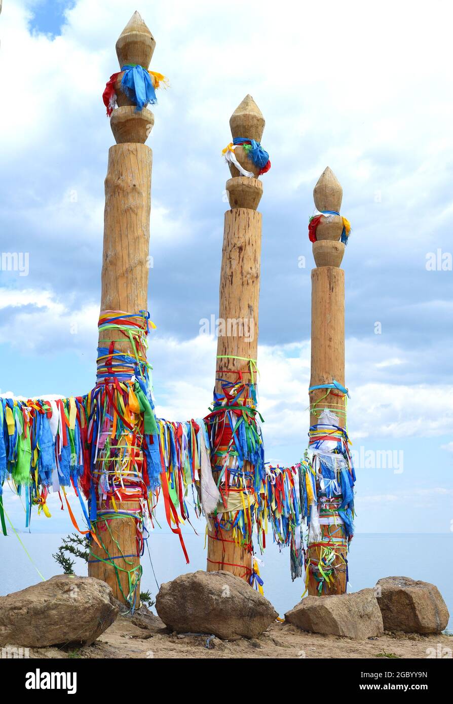 Colorful ribbons on hitching posts of shamanism religion in Khuzhir, island Olkhon. Stock Photo