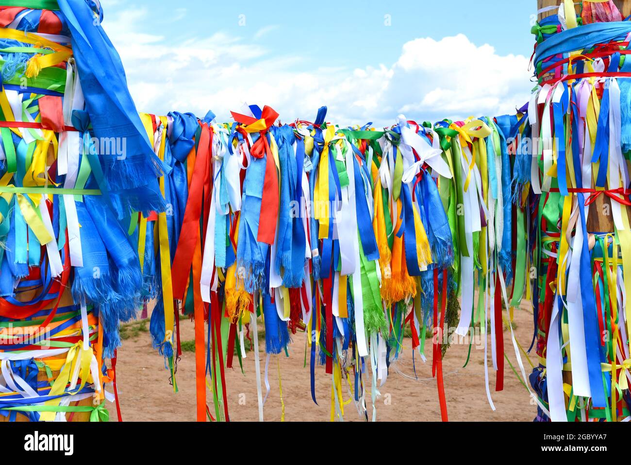 Colorful ribbons on hitching posts of shamanism religion in Khuzhir, island Olkhon. Stock Photo